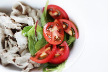 Japanese food, boiled pork served with spinach leaves and tomato salad 