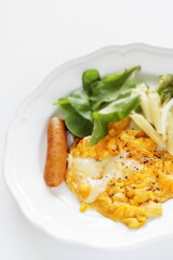 Scrambled egg served with pasta salad and sausage