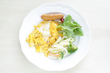 Scrambled egg served with pasta salad and sausage