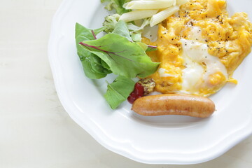Scrambled egg served with pasta salad and sausage