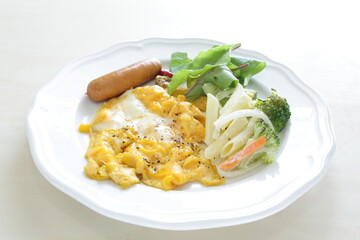 Scrambled egg served with pasta salad and sausage