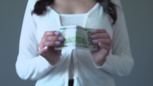 Young woman selec the USD dollar and reject euro eur, israel shekel NIS, Ukrainian hryvnia and Czech koruna CZK banknotes. Currency exchange rate concept. Selective focus