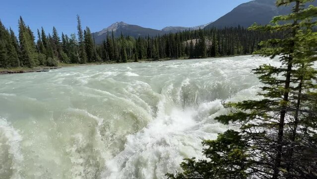 Majestic Athabasca Falls cascading down the rocky cliffs of Jasper National Park, Alberta, Canada. Beautiful view of Athabasca Falls and the powerful waters rushing through its narrow gorge