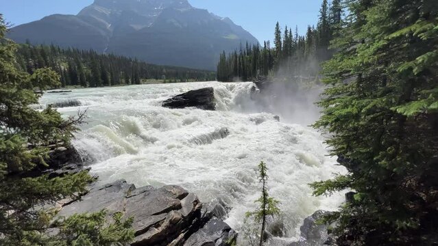 Majestic Athabasca Falls cascading down the rocky cliffs of Jasper National Park, Alberta, Canada. Beautiful view of Athabasca Falls and the powerful waters rushing through its narrow gorge