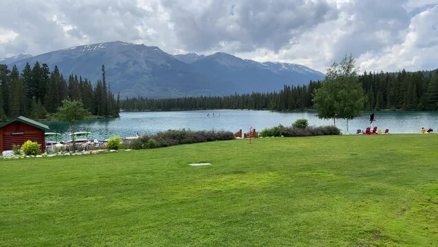 View of Beauvert Lake at Jasper, Alberta,Canada in a summer. The pristine alpine lake is surrounded by forest with mountain peaks in the distance. 