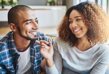 Happy, cute and in love couple looking playful and happy together, relaxing at home while having a casual weekend. Loving, affectionate and smiling boyfriend and girlfriend having quality time inside