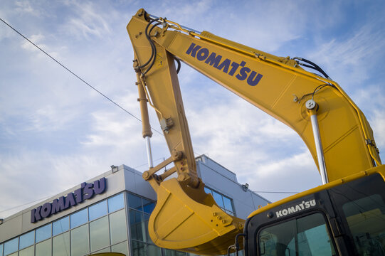 Novosibirsk, Russia. May 2, 2022 - The bucket of the Komatsu excavator against the blue sky and the building. New construction equipment. Selective focus