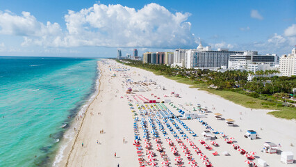 Drone aerial view at Miami South Beach Florida. Beach with colorful chairs and umbrellas, top view...