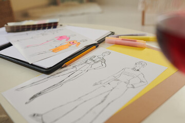 Paper sheets with fashion sketches on desk of designer, selective focus