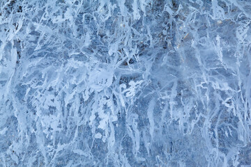 Texture of winter ice on a stone cliff. Blue natural ice background