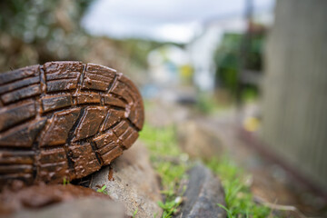 Muddy boots on a farm in Australia. Dirty shoes covered in dirt and foot and mouth disease. Bio security to stop contaminated footwear and clothes spreading disease in cows