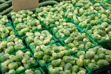 A view of several cartons of Brussels sprouts, on display at a local farmers market.