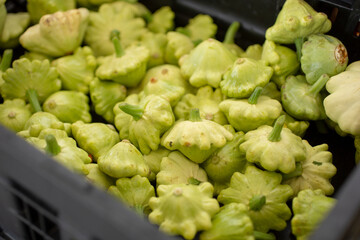 A view of a crate full of patty pan squash, on display at a local farmers market.