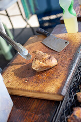 A view of a butcher block with a portion of cooked carnitas.