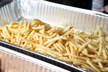A view of a large aluminum tray full of french fries.