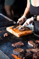 A view of a cook slicing a ribeye steak on a Himalayan pink salt block, seen at a local food festival.
