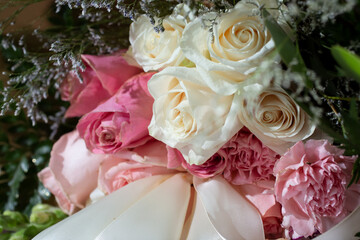 A closeup view of a bouquet of white and pink roses.
