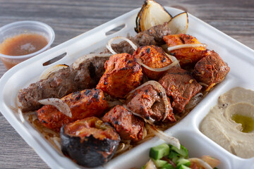 A view of a kebab combination plate, featuring kofta, chicken kebab, and beef kebab.