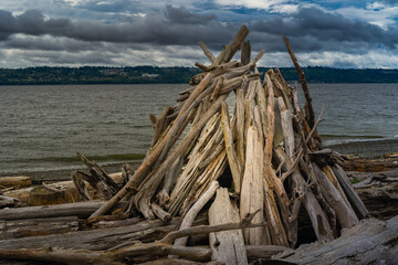 Fototapeta na wymiar 2022-08-04 A FORT BUILT OUT OF DRIFTWOOD ON THE SHORES OF WHIDBEY ISLAND WASHINGTON WITH A CLOUDY SKY