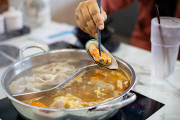 Chopsticks pick up clams to cook at Shabu.