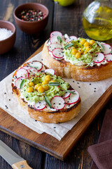 Bruschetta with guacamole, radish, white cheese, chickpeas and sage. Vegetarian food. Sandwich. Italian food.