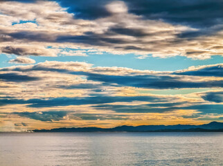 Threatening storm clouds over calm water and coastline