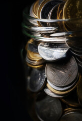 Macro shot of a large quantity of  Thai baht coins in glass jar, Saving money concept.