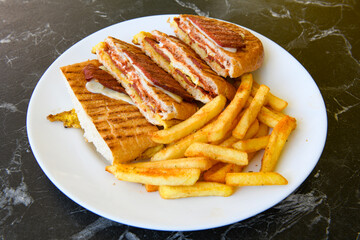 Turkish toast, mixed toast with cheddar cheese, sausage and ham, with fried potatoes (Turkish name; Bazlama Karisik tost)