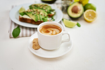Freshly made Avocado and cream cheese toasts on a white ceramic plate and ingredients
