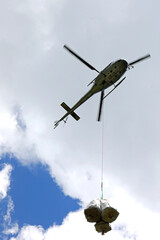 helicopter carrying material attached to a hook