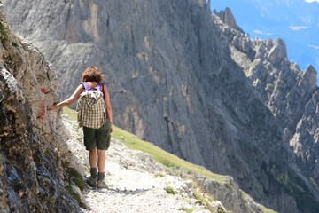 person with backpack during a summer hiking in the Dolomites