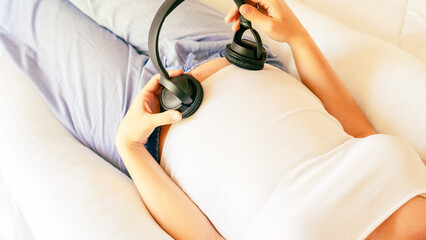 Pregnant music woman listen. Mother belly listen headphones sound. Pregnancy woman listening to...