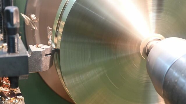 Close-up the lathe machine finish cutting the brass disk parts by lathe tools.