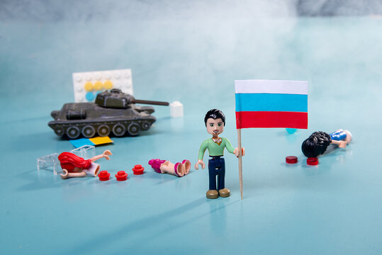Zaporozhye, Ukraine, April 19, 2022. Russian military aggression 24.02.2022. lego man with the flag of ukraine in smoke and a tank on a blue background