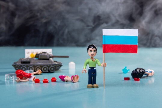 Zaporozhye, Ukraine, April 19, 2022. Russian military aggression 24.02.2022. lego man with the flag of ukraine in smoke and a tank on a blue background