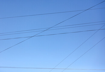 Electric wires against the blue sky. Background