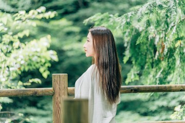 森林浴する美髪の日本人女性（スピリチュアル・パワースポット）
