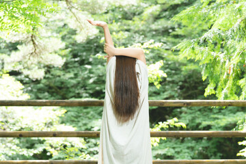 Naklejka premium 森の中でストレッチする女性 