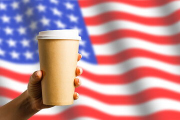 Closeup of American flag with coffee paper cup.