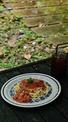 Spaghetti with ketchup and ham is a delicious backyard lunch. Lunch in the garden. with coffee.
