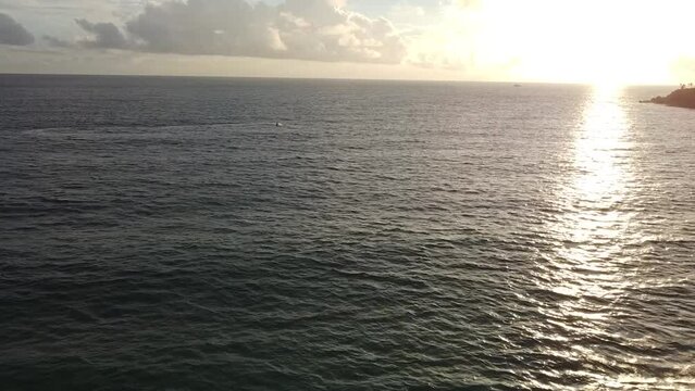 Sea landscape at sunset, jetski cruising on the water.