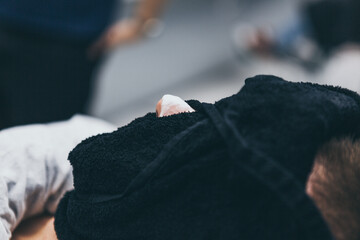 Barbershop customer with warm towel on the face