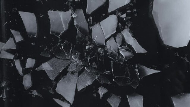 Slow motion shot of ice breaking on black background.
