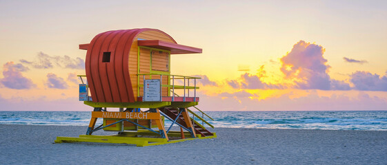 Obraz premium Lifeguard hut on the beach in Miami Florida, colorful hut on the beach during sunrise Miami South Beach. Sunny day on the beach