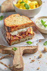 Healthy and homemade sandwich with chicken, fruits, herbs and onion.