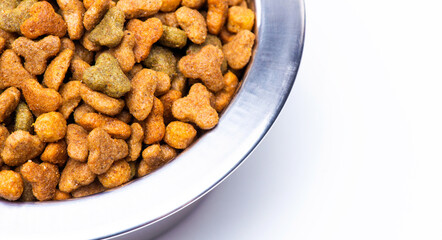 A close-up of part of a metal bowl with dry food for animals, cats and dogs