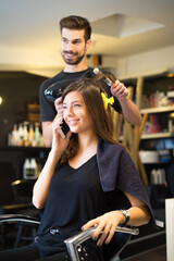 Young woman getting new hairstyle from hairdresser in the modern hair salon