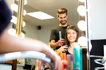 Young woman getting new hairstyle from hairdresser in the modern hair salon