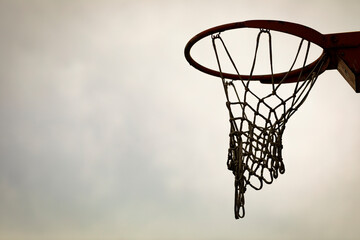 Silueta de una canasta de baloncesto (basket, basketball) durante un atardecer de verano (outdoor...