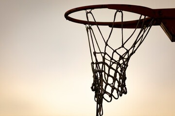 Silueta de una canasta de baloncesto (basket, basketball) durante un atardecer de verano (outdoor al aire libre) - obrazy, fototapety, plakaty